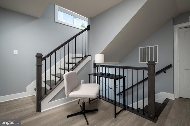 staircase with lofted ceiling and wood-type flooring