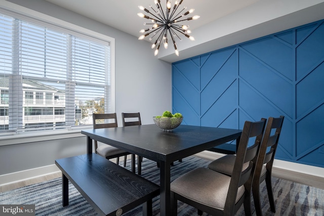 dining area featuring wood-type flooring and a notable chandelier