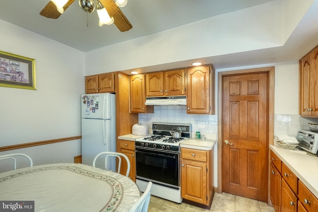 kitchen with white appliances, ceiling fan, and tasteful backsplash