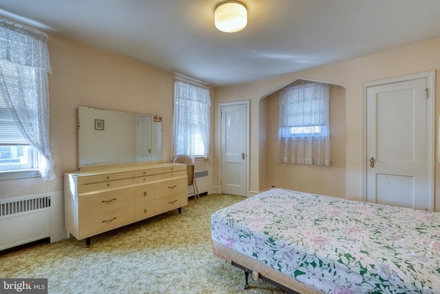 carpeted bedroom featuring radiator