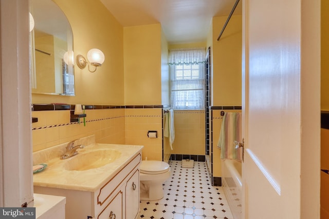 full bathroom featuring tile walls, bathing tub / shower combination, vanity, and toilet