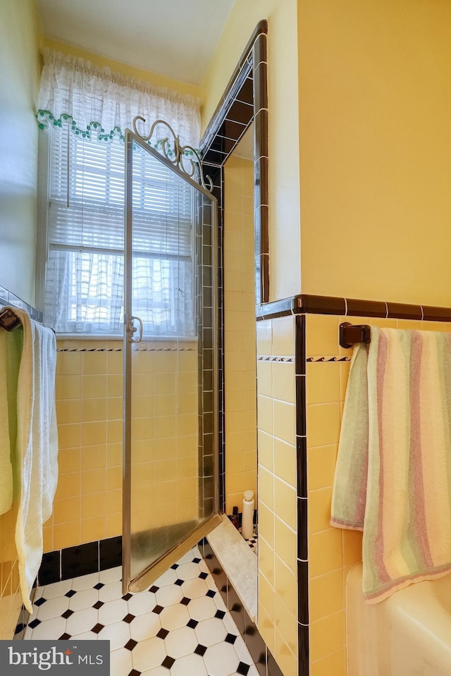 bathroom with walk in shower and tile walls