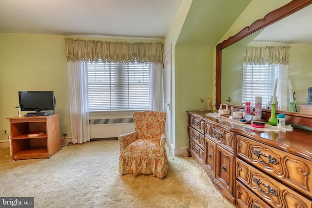 living area with light colored carpet and radiator heating unit