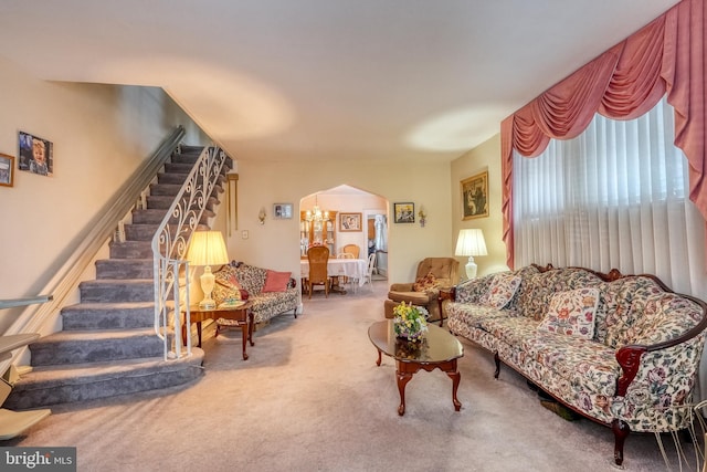 carpeted living room featuring a chandelier