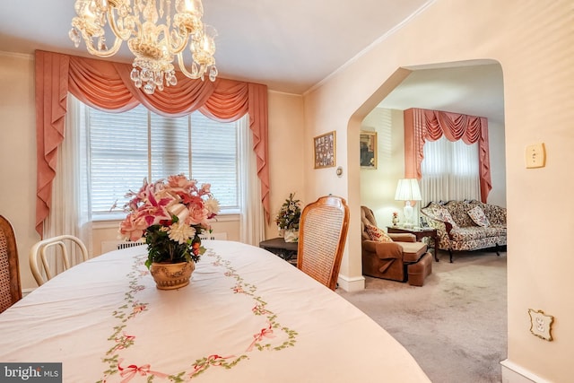 dining room with carpet floors, ornamental molding, and a chandelier