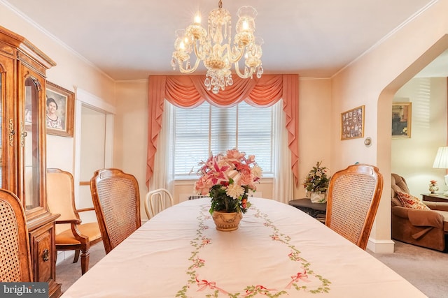 carpeted dining room featuring ornamental molding and a chandelier