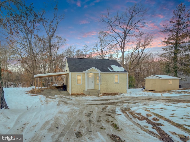 snow covered structure with a carport