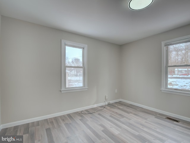 unfurnished room featuring light hardwood / wood-style flooring and a healthy amount of sunlight