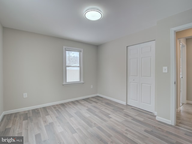 unfurnished bedroom featuring light hardwood / wood-style flooring and a closet