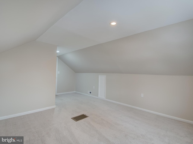 bonus room with light carpet and vaulted ceiling