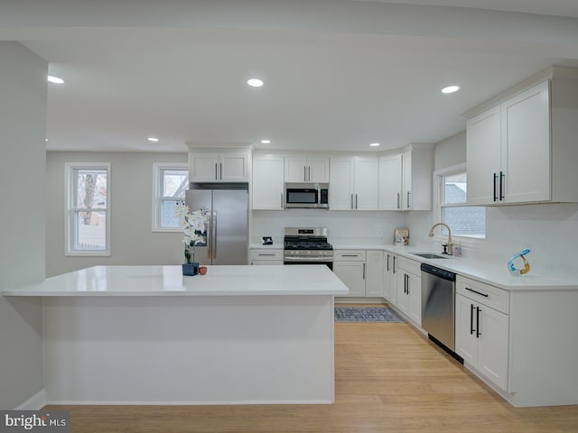 kitchen featuring sink, white cabinetry, plenty of natural light, stainless steel appliances, and light hardwood / wood-style floors