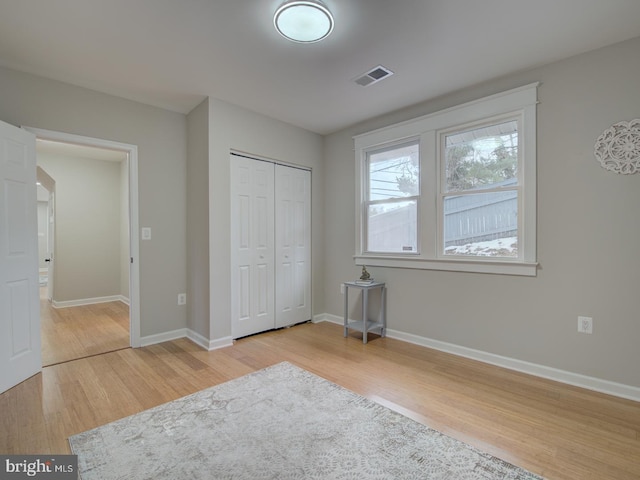 unfurnished bedroom featuring a closet and light wood-type flooring