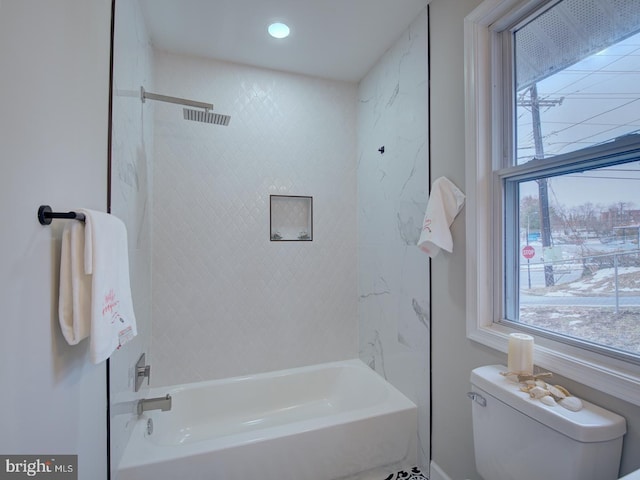 bathroom featuring tiled shower / bath and toilet