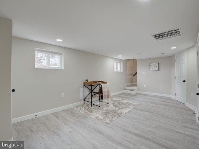 basement with light hardwood / wood-style flooring