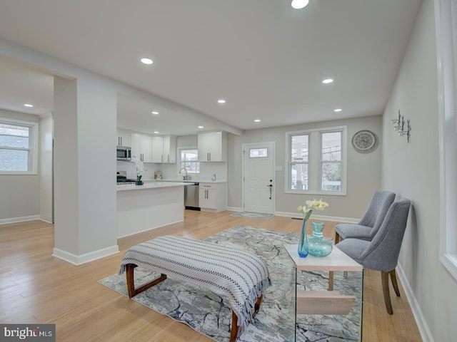 living room featuring sink, a wealth of natural light, and light hardwood / wood-style flooring