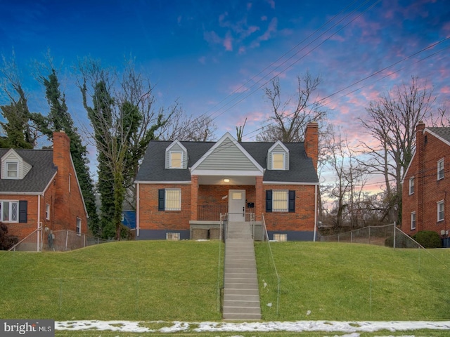 cape cod home with a lawn