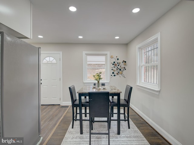 dining area with plenty of natural light and dark hardwood / wood-style flooring