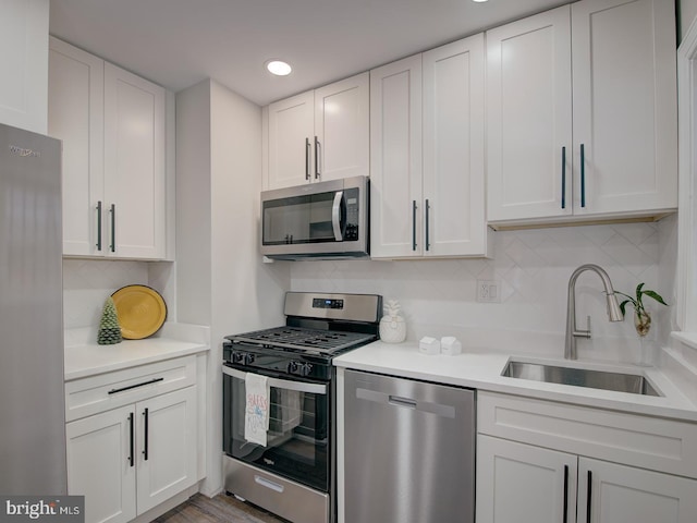 kitchen with white cabinetry, appliances with stainless steel finishes, sink, and decorative backsplash