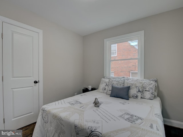 bedroom with dark hardwood / wood-style floors