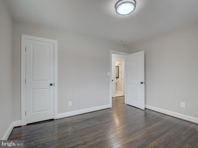 unfurnished room featuring dark wood-type flooring