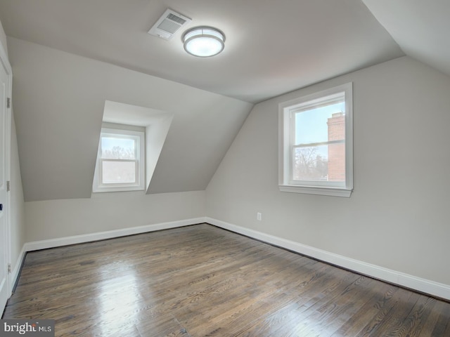 additional living space featuring plenty of natural light, dark hardwood / wood-style flooring, and vaulted ceiling