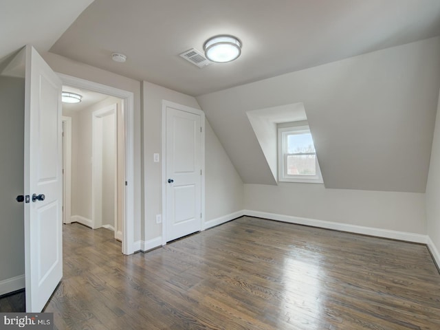 bonus room with vaulted ceiling and dark wood-type flooring