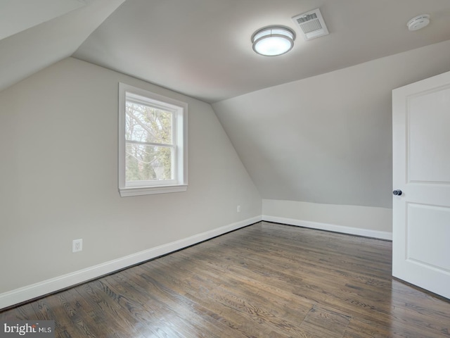 additional living space featuring lofted ceiling and dark hardwood / wood-style flooring