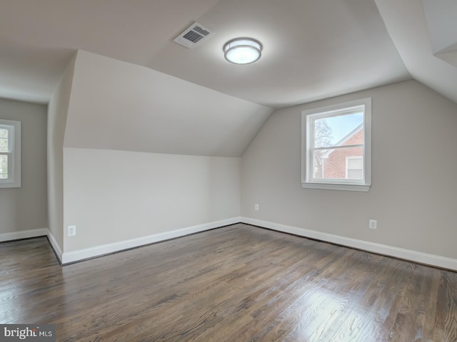 bonus room with vaulted ceiling and dark hardwood / wood-style flooring