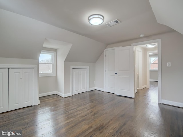 additional living space with dark wood-type flooring and vaulted ceiling