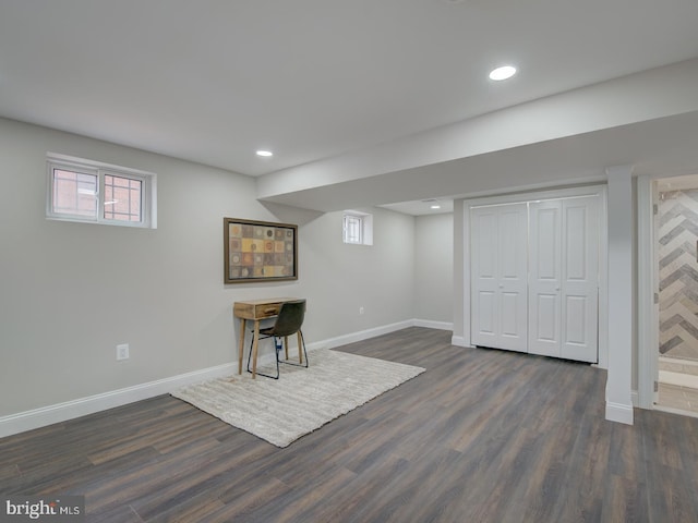 basement featuring a wealth of natural light and dark hardwood / wood-style floors