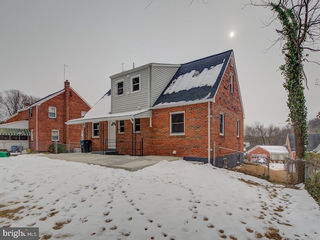 view of snow covered rear of property