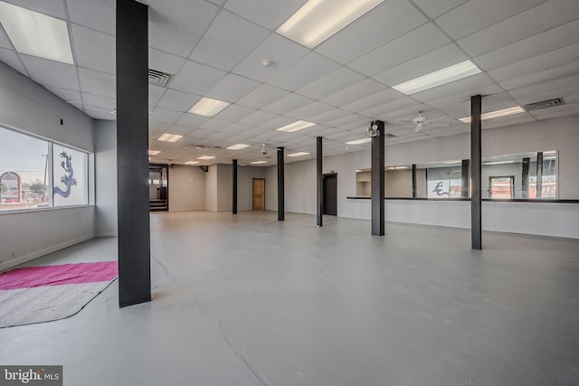 basement with ceiling fan and a drop ceiling