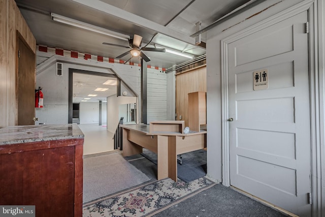 interior space featuring wooden walls and ceiling fan