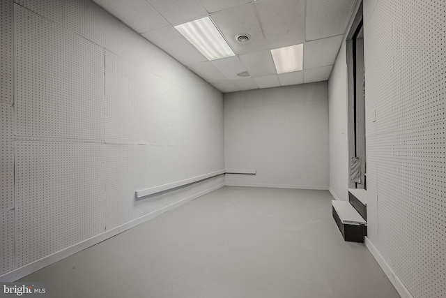 spare room featuring concrete floors and a drop ceiling