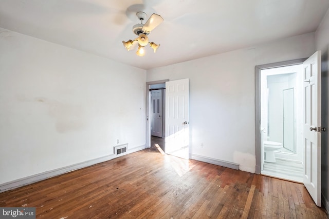 unfurnished bedroom featuring ensuite bathroom, hardwood / wood-style floors, and ceiling fan