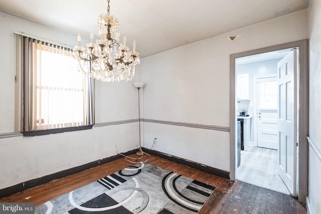 interior space with a chandelier, plenty of natural light, and dark wood-type flooring