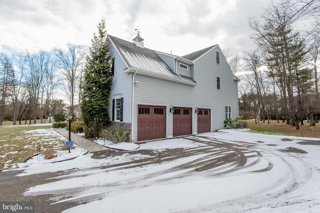 snow covered property with a garage