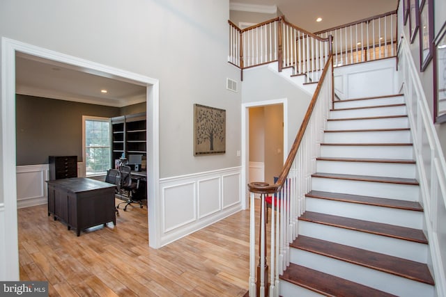 stairs featuring hardwood / wood-style flooring and ornamental molding