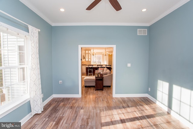 unfurnished room with a healthy amount of sunlight, wood-type flooring, and crown molding