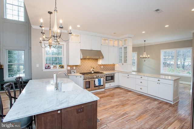 kitchen with white cabinets, sink, light stone counters, and stainless steel appliances