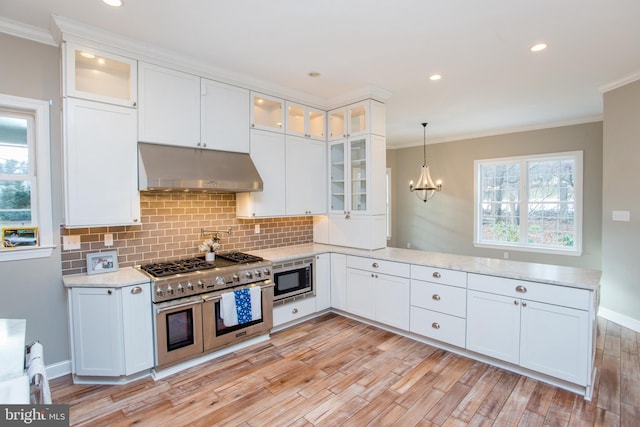 kitchen with white cabinetry, stainless steel appliances, and hanging light fixtures