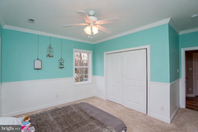 unfurnished bedroom featuring ceiling fan, light carpet, a closet, and ornamental molding