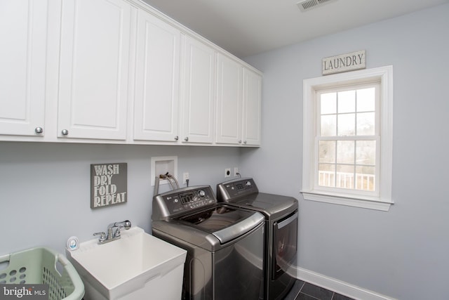 laundry room with cabinets, a healthy amount of sunlight, separate washer and dryer, and sink