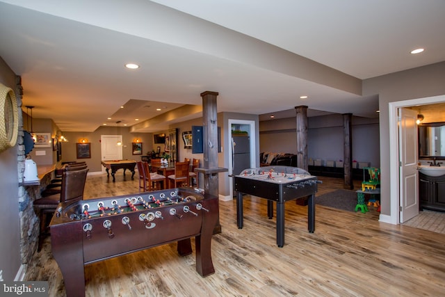 playroom featuring light hardwood / wood-style floors, sink, and ornate columns