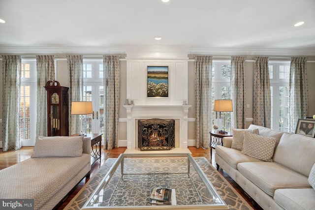 living room with hardwood / wood-style floors, crown molding, a fireplace, and french doors