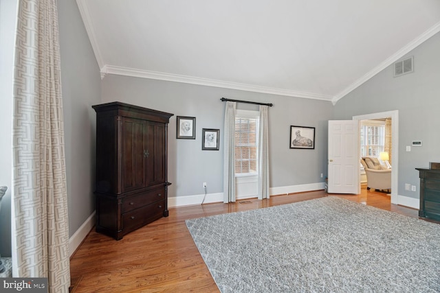 bedroom with ornamental molding, ensuite bathroom, vaulted ceiling, and light wood-type flooring