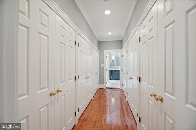 hallway with hardwood / wood-style floors and ornamental molding