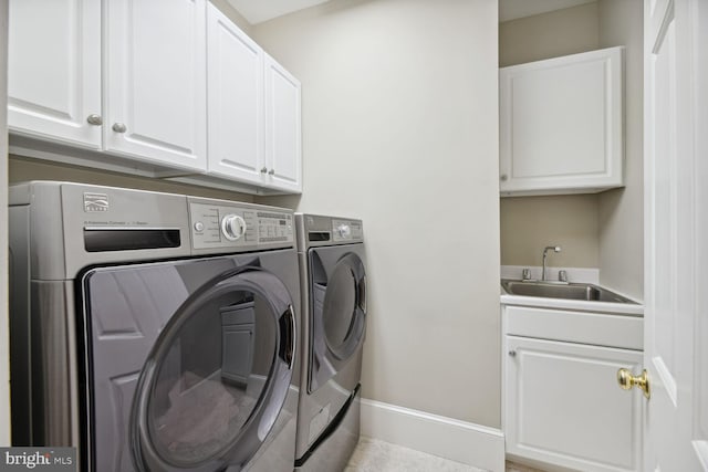 washroom featuring sink, light tile patterned floors, cabinets, and washing machine and clothes dryer