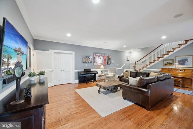 living room with ornamental molding and light hardwood / wood-style floors