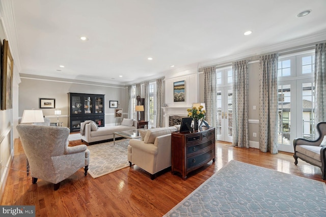 living room featuring hardwood / wood-style flooring, crown molding, and french doors